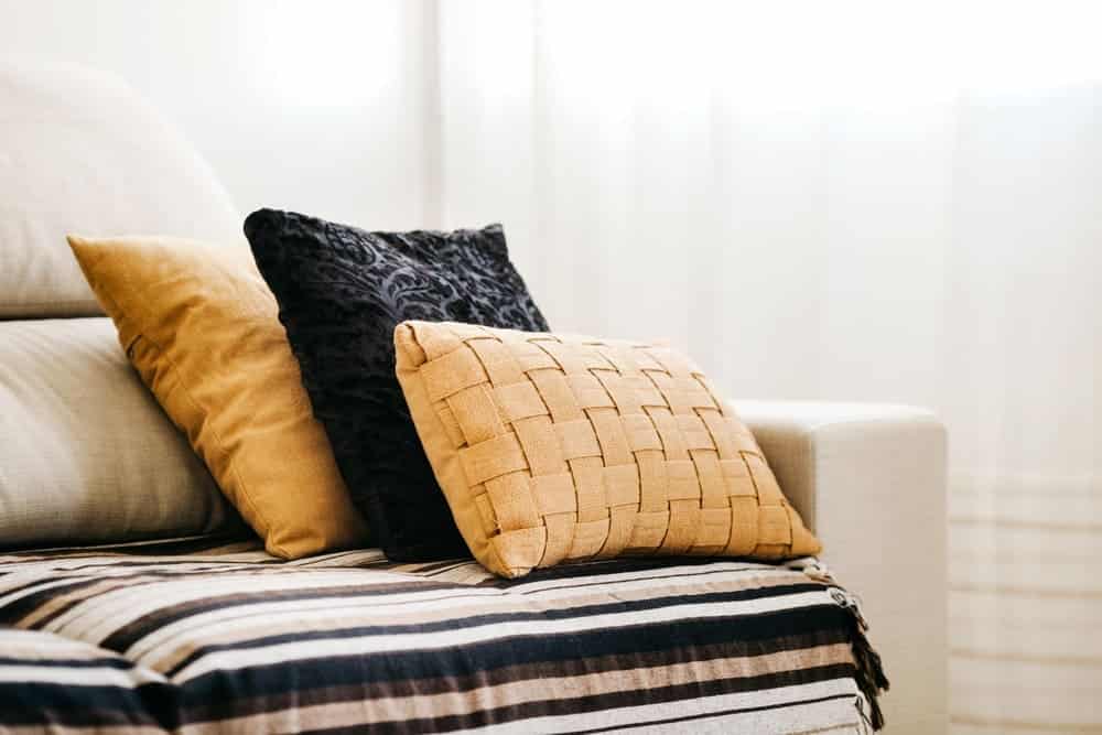 almohadas negras amarillas sofá blanco