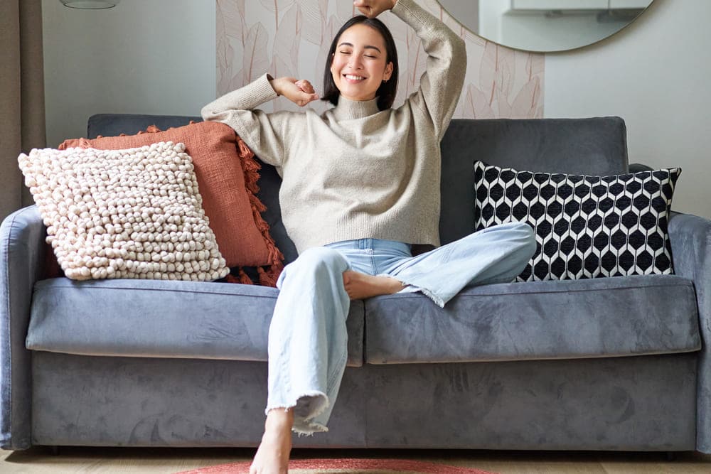 retrato feliz mujer estirandose en sofa