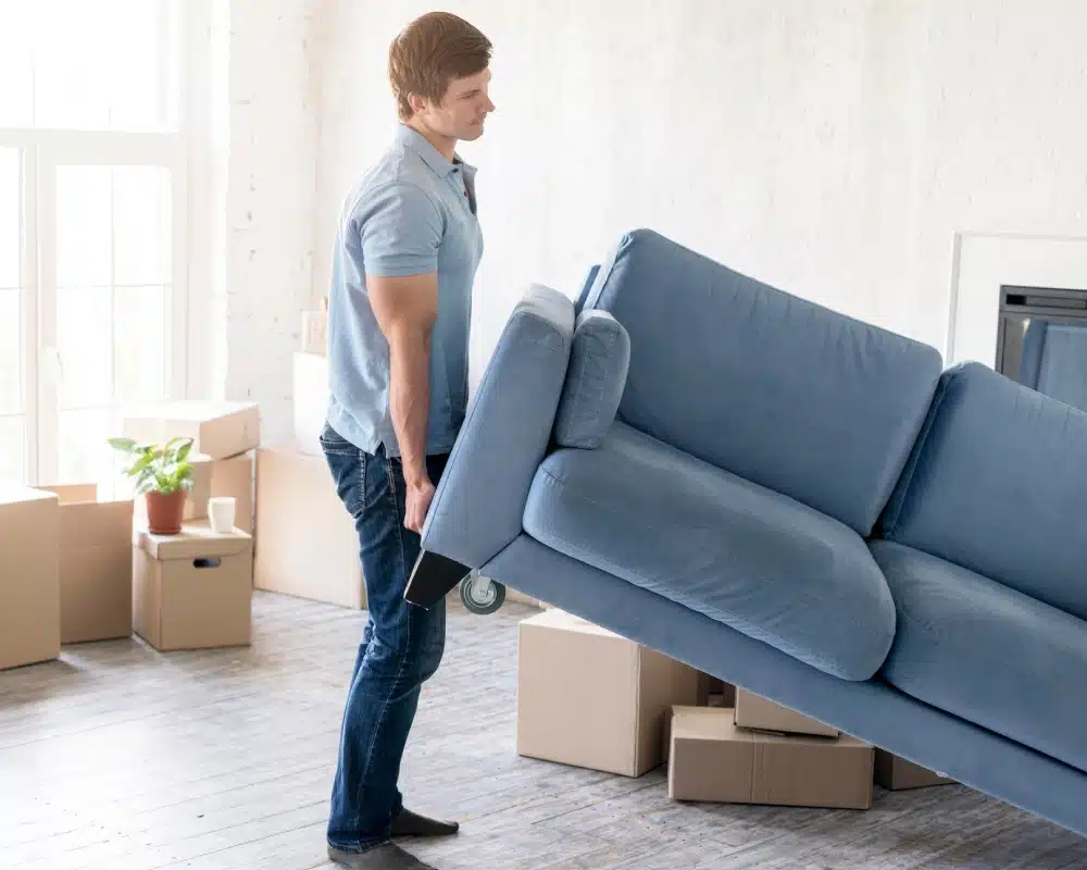 hombre sujetando un sofa